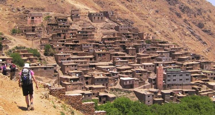 Excursionista acercándose a un pueblo serrano densamente poblado.