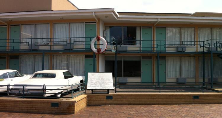 Un motel historique avec des voitures vintage garées dehors.