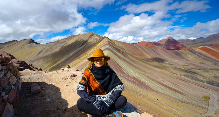 Individual sitting in front of Rainbow Mountain.