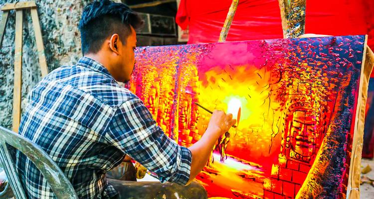 Artista pintando una obra de arte vibrante al aire libre.