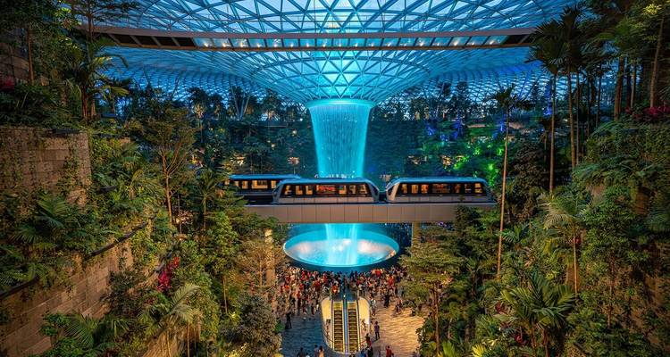 Innenwasserfall mit lebendiger Vegetation und Menschen, die die Attraktion betrachten.