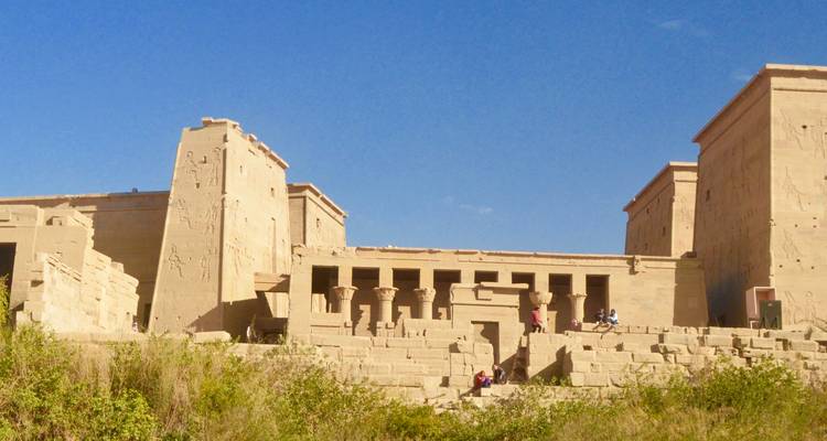 Historische stenen tempel met mensen op de trappen.
