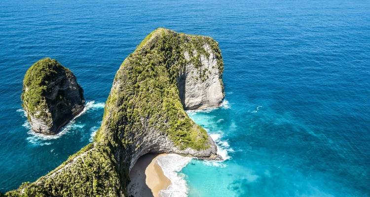 Luchtfoto van een rotsachtig eiland met blauw water.