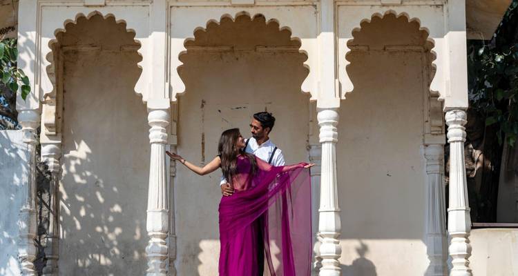 Couple posing under traditional arches in India.