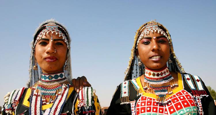Women in traditional attire posing together.