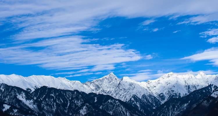 Snow-capped mountain peaks with clear blue sky.