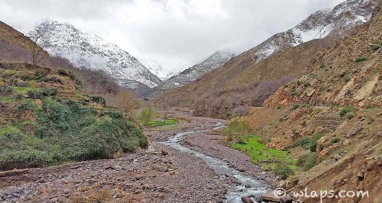Mountainous landscape with a flowing river, with a watermark