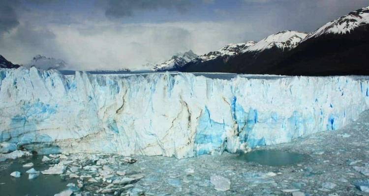 Glacier avec des pics glacés et un ciel nuageux.