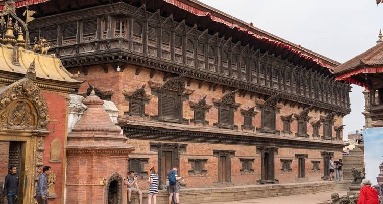Bâtiment traditionnel avec des touristes à proximité.