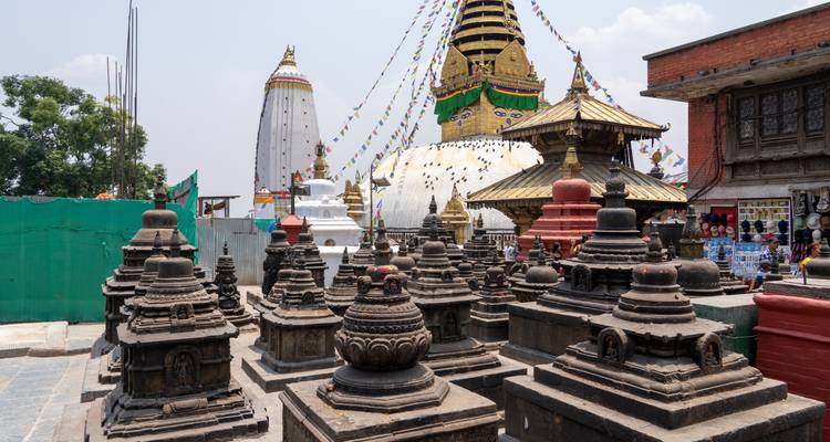 Cour de temple avec un grand stupa et des structures plus petites environnantes.