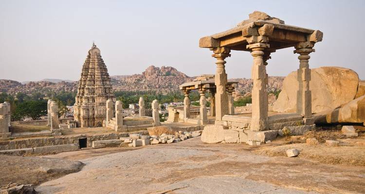 Les temples en pierre historiques et les piliers dispersés à travers le paysage antique de Hampi