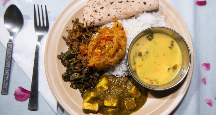 Primer plano de un plato thali indiano tradicional con arroz, dal, curry de paneer y verduras.