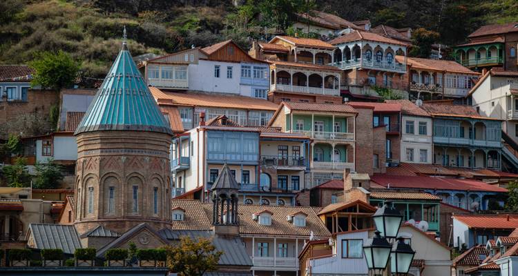 Colorful historic houses and a church in a cityscape.