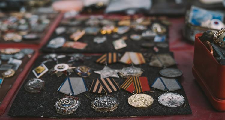 Assortment of medals and badges on a market stall.