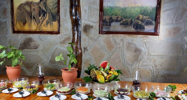 Bowls of food on a table with decorative fruit and plant elements.