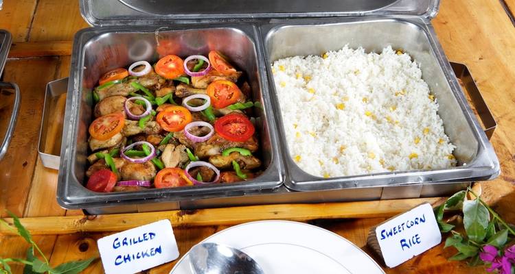 Buffet trays with dishes labeled 'Grilled Chicken' and 'Sweetcorn Rice'.