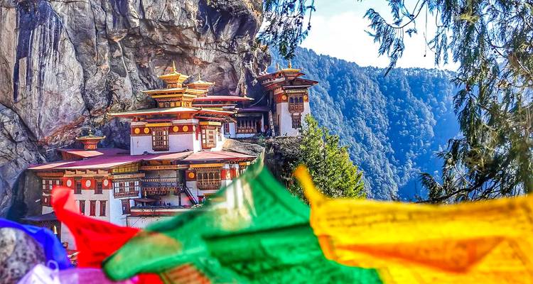 Taktsang-klooster met gebedsvlaggen op de voorgrond.