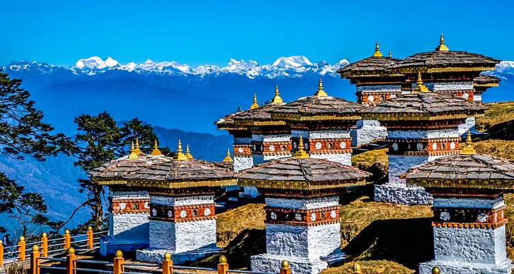 Reeks traditionele Bhutanese stupa's met bergen.