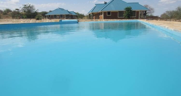 Piscine bleue avec bâtiments adjacents.