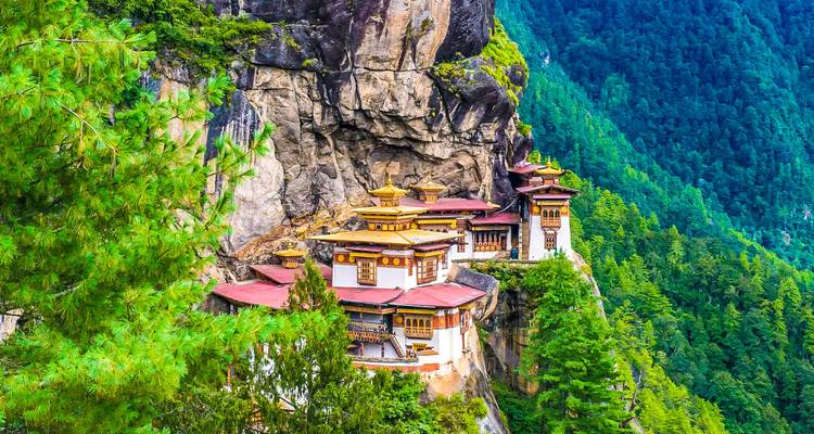 Taktsang Monastery on a steep cliff with forest.