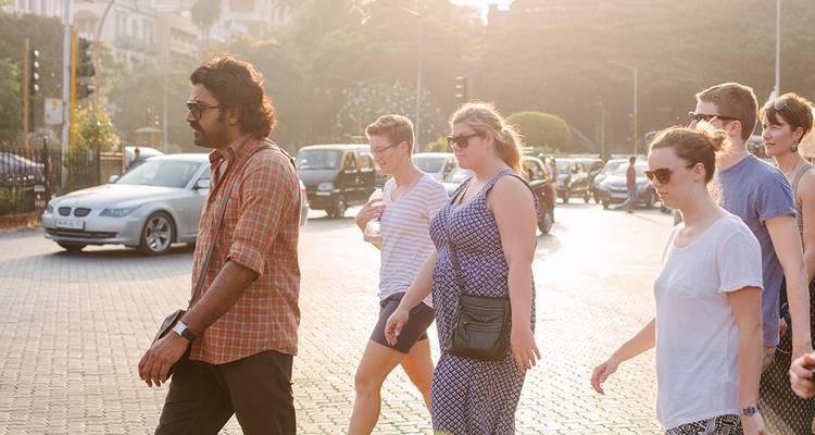Eine Gruppe von Menschen auf einer sonnenbeschienenen Straße.
