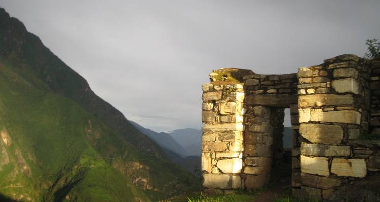 Stone ruins on the edge of a mountain with misty background.