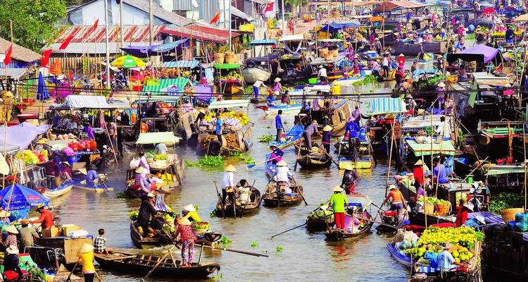 Un mercado flotante bullicioso con muchas embarcaciones y vendedores.