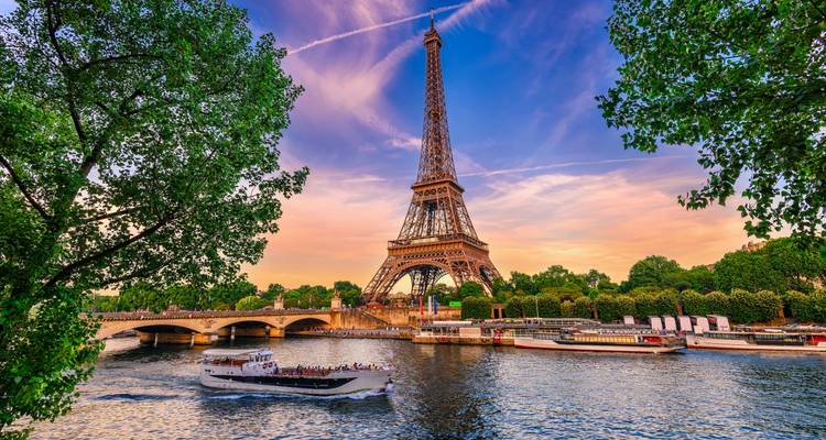 Tour Eiffel près de la Seine sous un ciel vibrant.