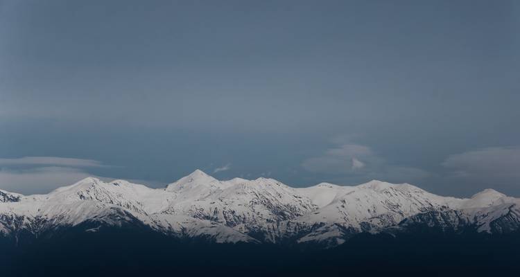 Snow-capped mountains under a clear, bright sky.