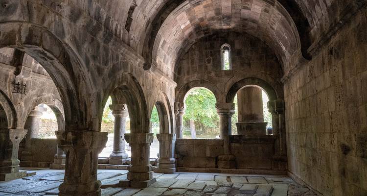 Interior of an ancient stone building with arches and columns.