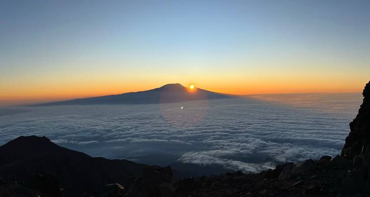 Vue du lever de soleil sur les montagnes avec des nuages en contrebas.