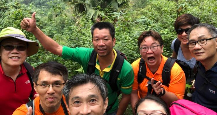 Fröhliche Trekkinggruppe posiert für ein nahes Selfie in dichter Dschungelumgebung