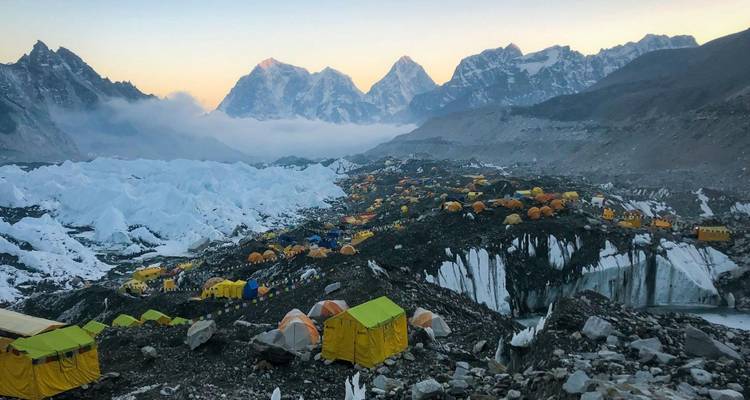 Aerial view of tents at Everest Base Camp with rugged mountains around.