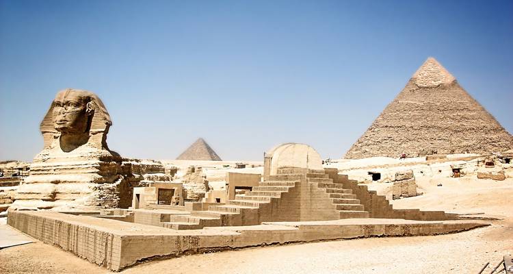 The Sphinx and pyramids under a clear sky.