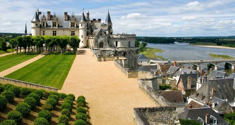 Château d'Amboise surplombant la Loire et les jardins à la française sous des nuages cotonneux.