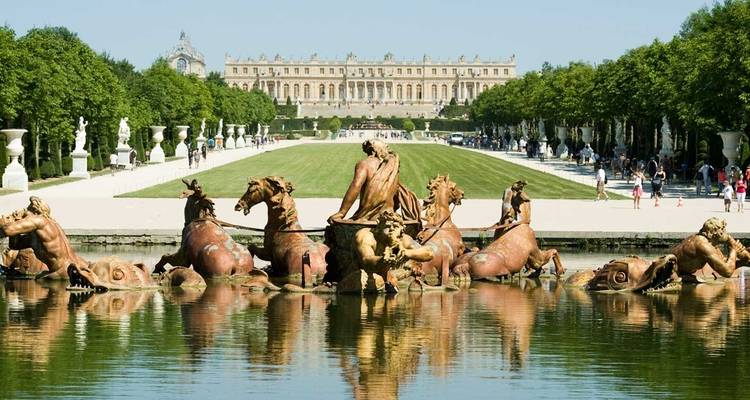 Fontaine d'Apollon dans les Jardins de Versailles avec la façade du palais s'étendant à l'horizon.