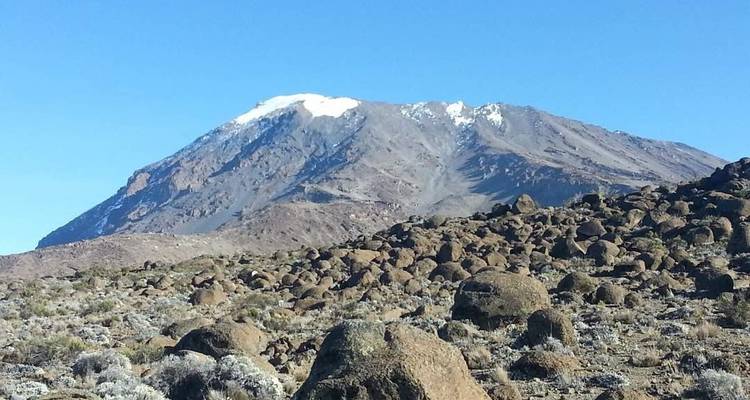 Sneeuwbedekte berg onder een heldere blauwe hemel.