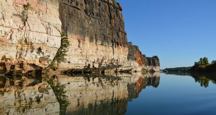 Cliffs reflecting on water creating a serene setting.