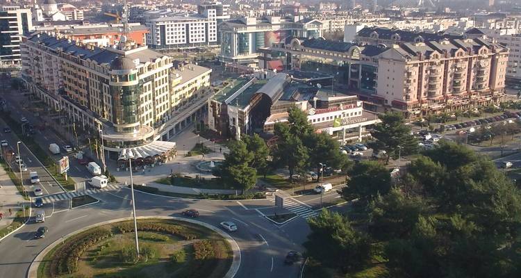 Luftaufnahme einer Stadt mit kreisförmiger Platzanordnung.
