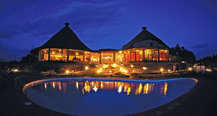 A building with a pool lit up at night.