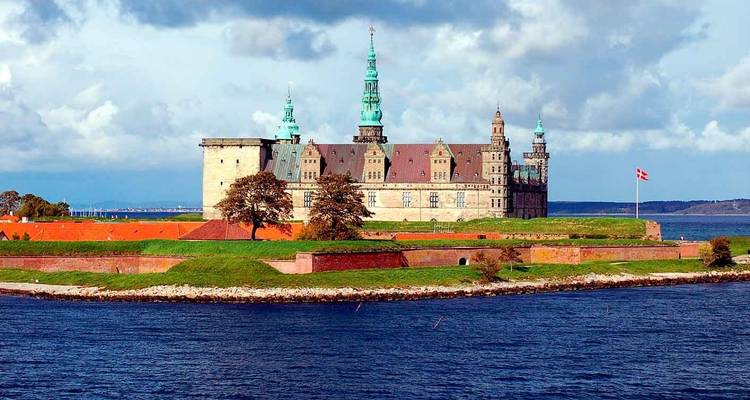 Kasteel Kronborg gelegen op een kaap met uitzicht op de Øresund met de Deense vlag wapperend.