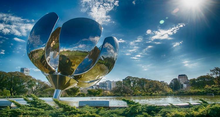 Los brillantes pétalos metálicos de la escultura Floralis Genérica reflejan el horizonte de Buenos Aires bajo el sol radiante