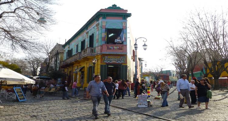 Las multitudes pasean por edificios pintados de colores brillantes y puestos callejeros a lo largo de la animada zona peatonal de Caminito
