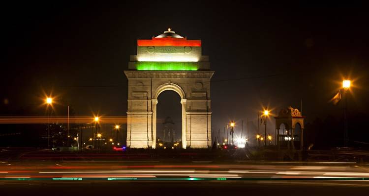 India Gate, 's nachts verlicht met lichtsporen van voertuigen.