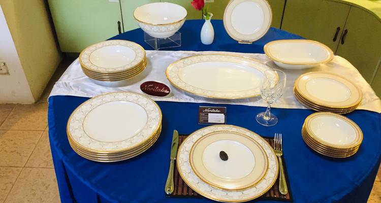 Élégante mise de table avec de la vaisselle Noritake disposée sur une nappe bleu royal, prête pour la présentation.