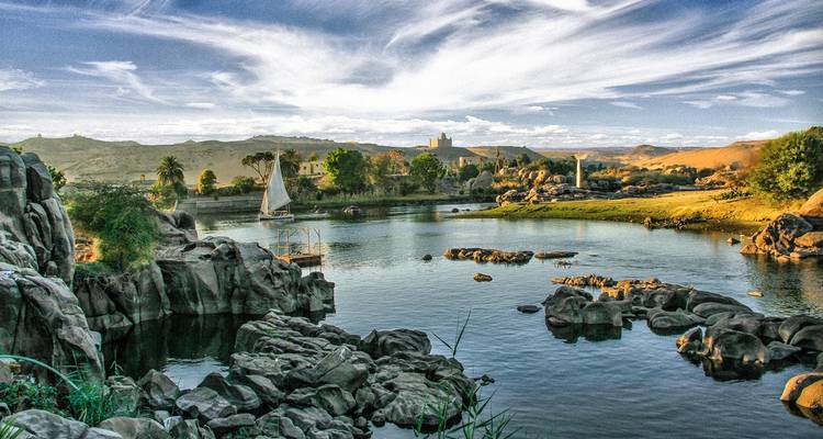 Beautiful landscape with river, rocks, and distant buildings.