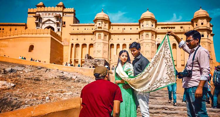 Une séance photo devant le Fort d'Amber avec des personnes en tenue traditionnelle.