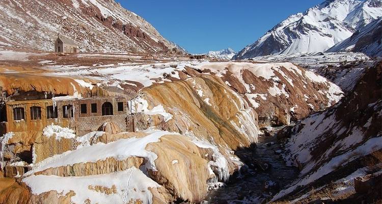 Formations rocheuses colorées avec de vieux bâtiments et de la neige.