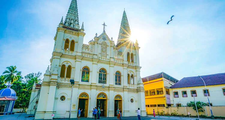 Façade d'église historique avec des visiteurs se prélassant au soleil.