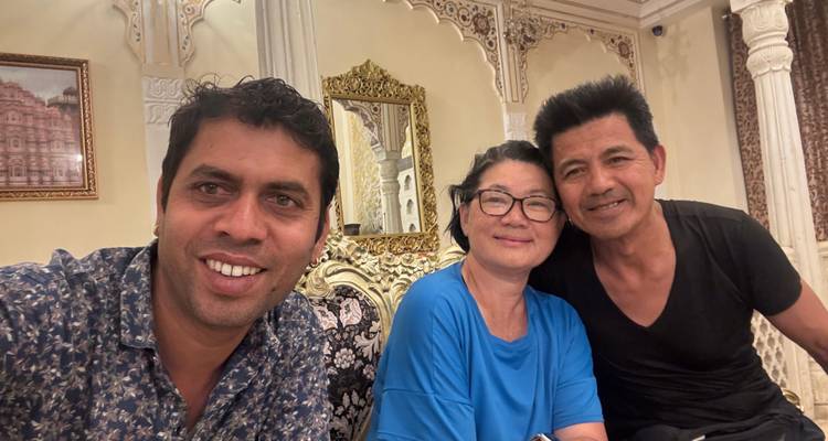 Three people sitting in an ornate room.